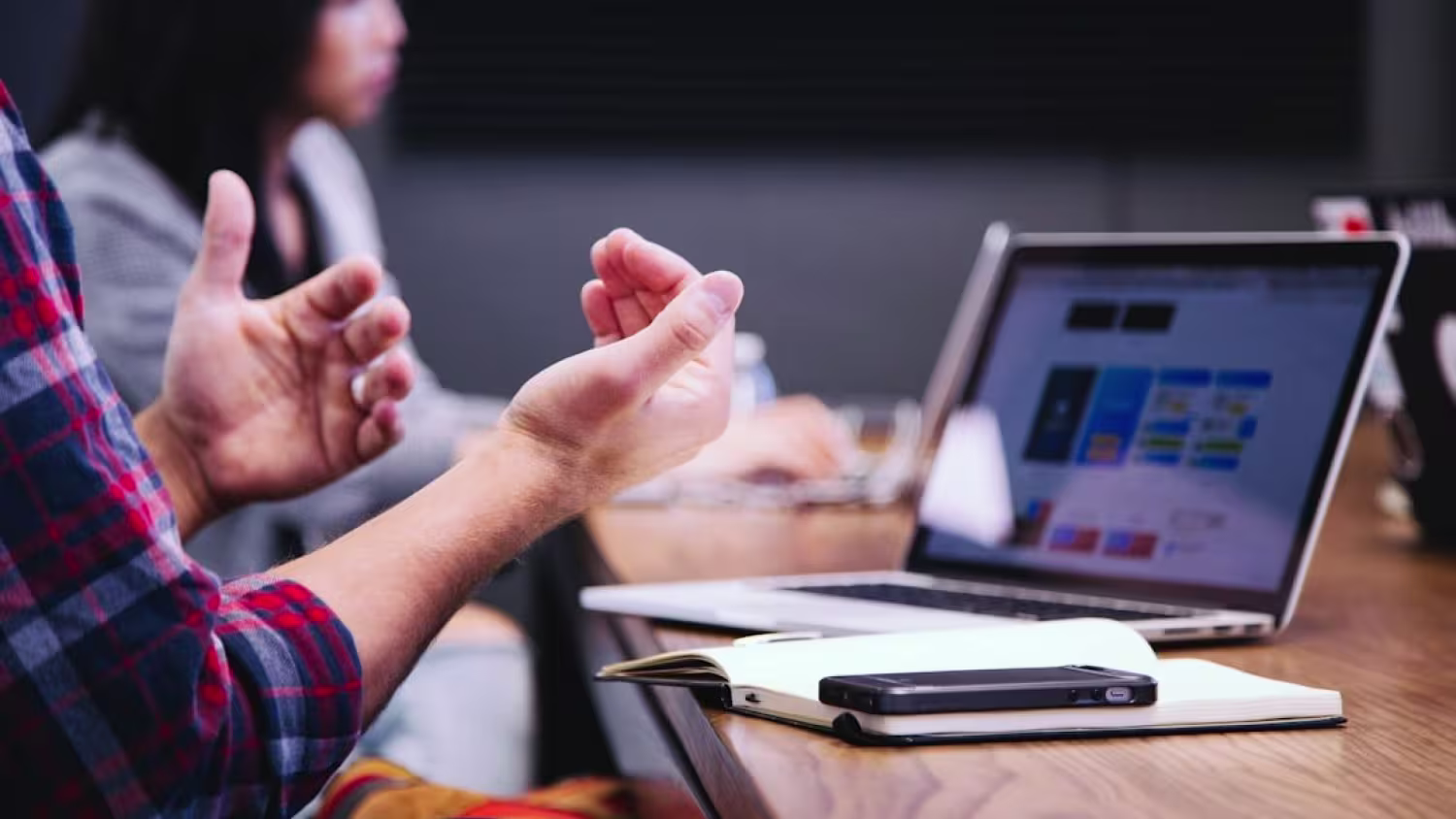 people working together in a meeting room with a laptop at the desk